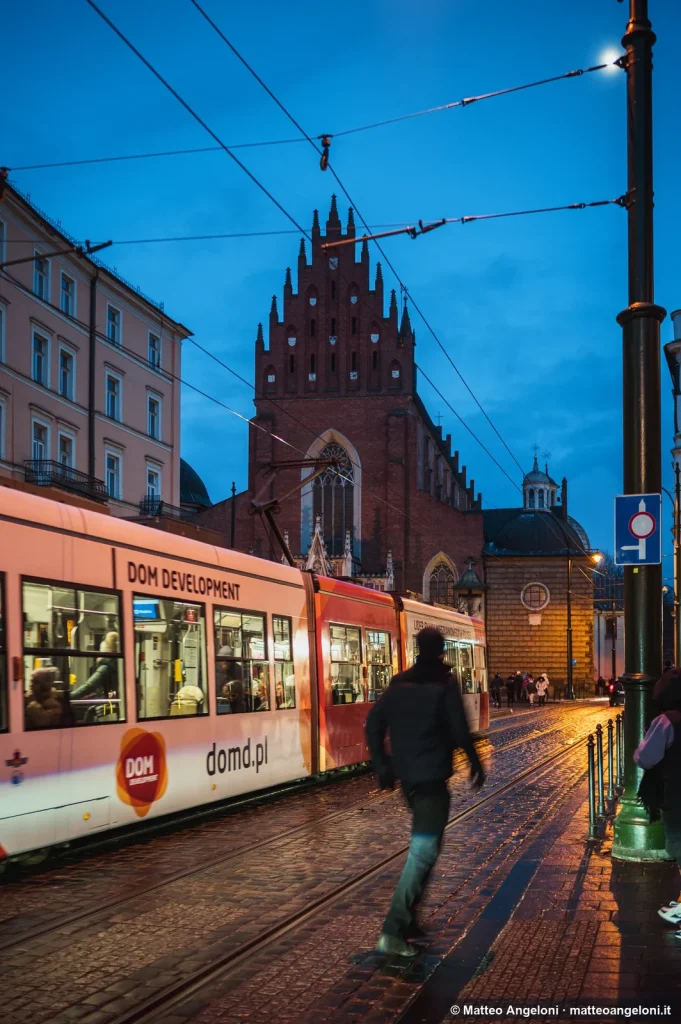 Tram davanti a una chiesa di Cracovia al tramonto