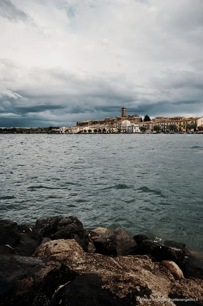 Borgo affacciato sul Lago di Bolsena sotto un cielo di tempesta
