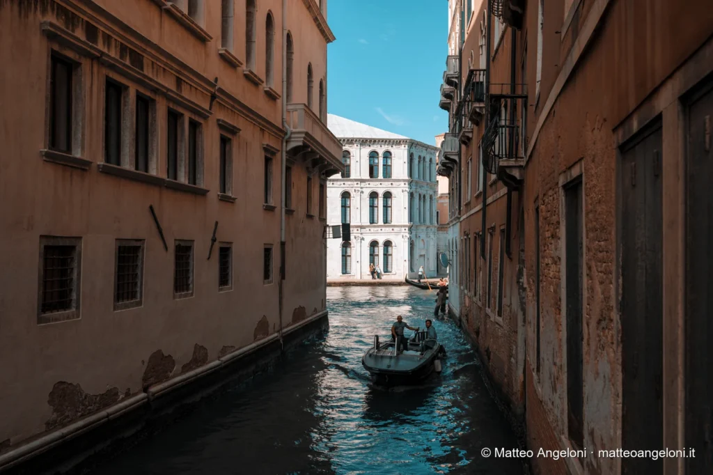 Gondola in un canale stretto sotto un ponte di Venezia