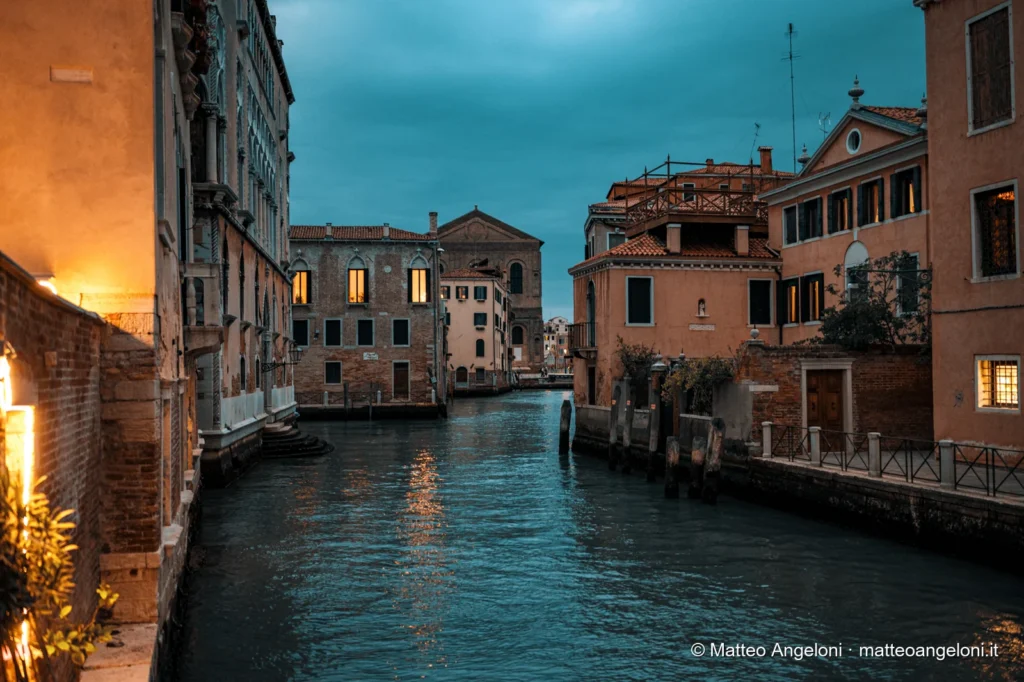 Luci serali riflesse nell'acqua di un canale veneziano