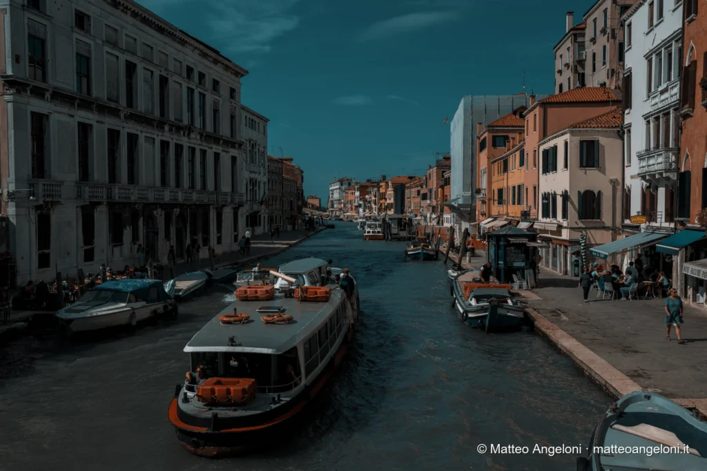 Vaporetto in navigazione tra i palazzi lungo un canale di Venezia