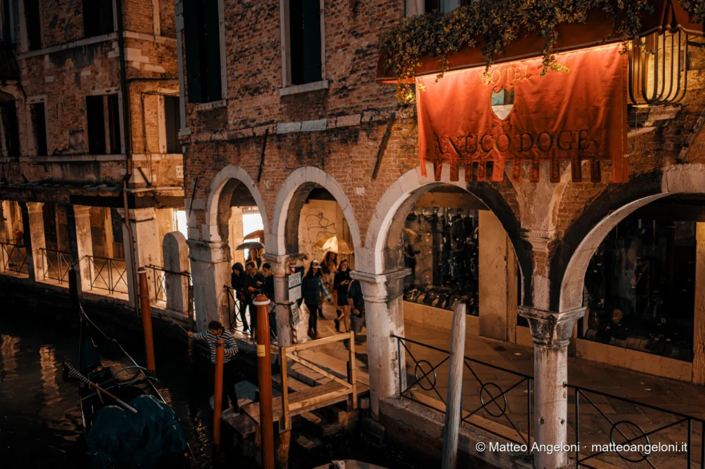 Ponte veneziano illuminato sopra un canale di notte